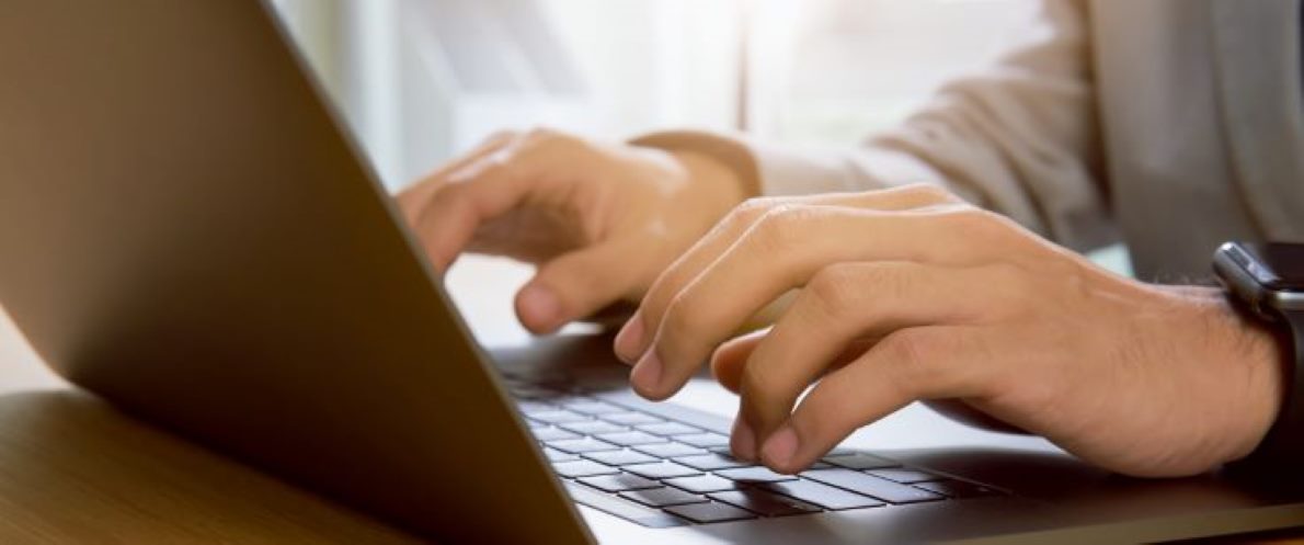 Close-up image of hands on a laptop